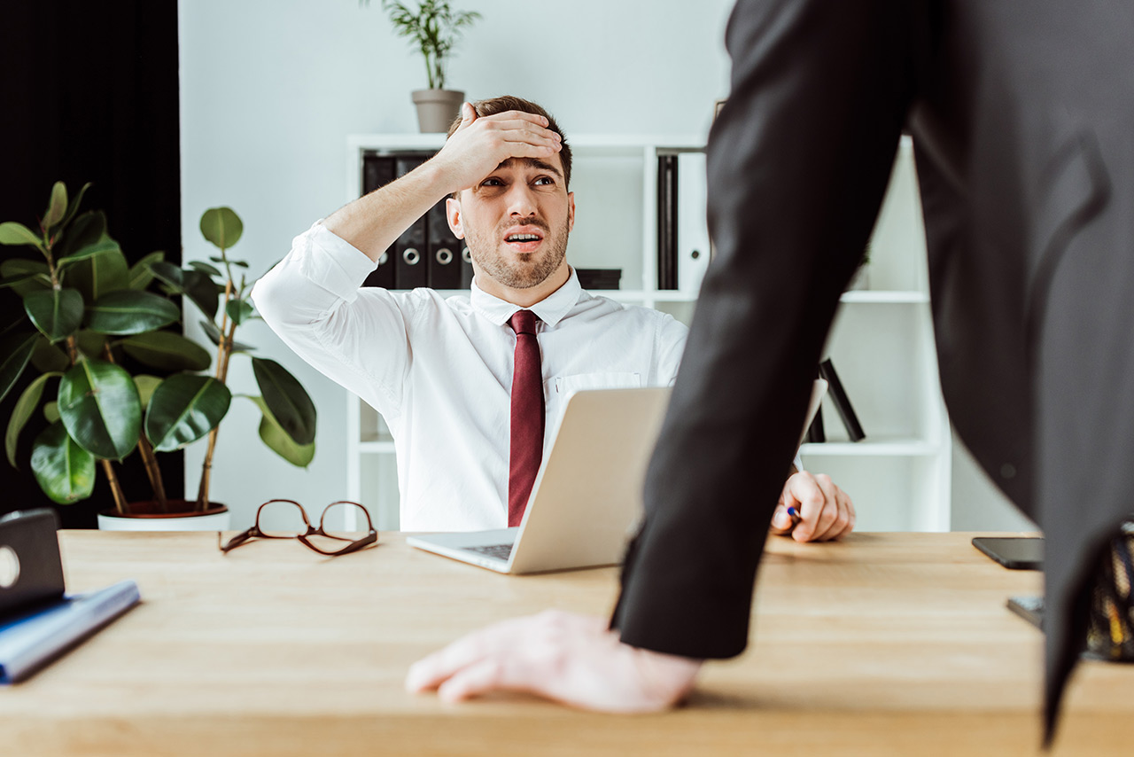 scared-businessman-with-laptop-looking-at-angry-bo-2021-08-30-19-53-12-utc_2K9VF4WA__